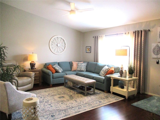 living area with dark wood-type flooring and a ceiling fan