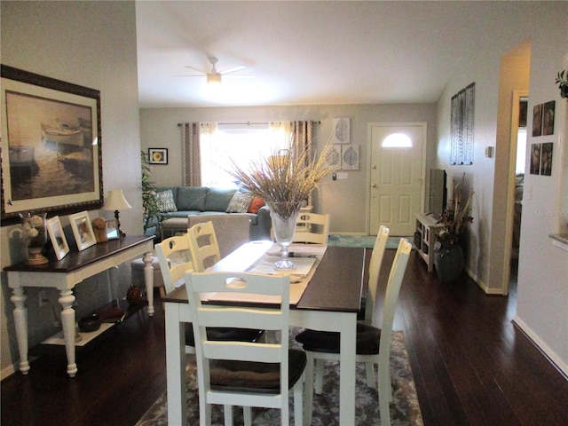 dining space with baseboards and dark wood-type flooring