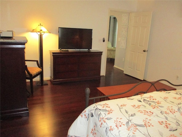 bedroom with baseboards and dark wood finished floors