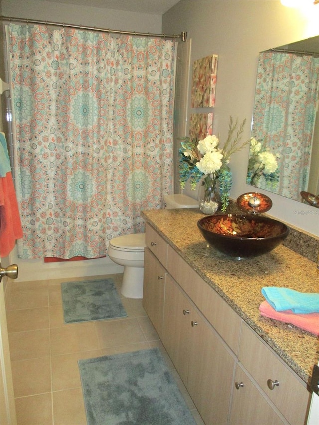 bathroom with toilet, tile patterned flooring, shower / bath combination with curtain, and vanity