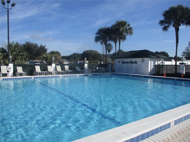 view of swimming pool featuring fence