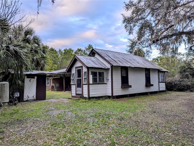 property exterior at dusk featuring a yard