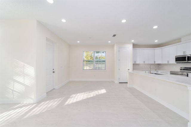 kitchen with sink, light tile patterned floors, white cabinets, and appliances with stainless steel finishes