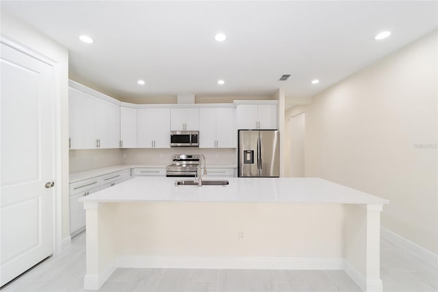 kitchen featuring white cabinetry, stainless steel appliances, sink, and a center island with sink