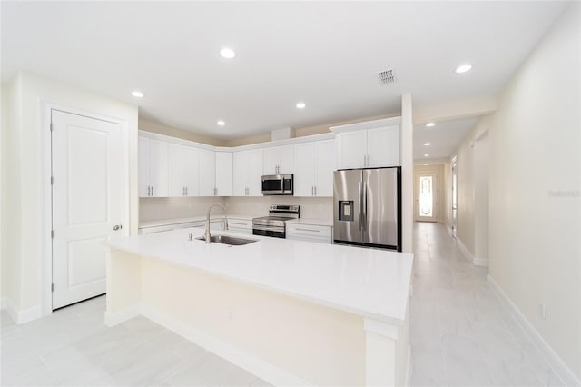 kitchen featuring white cabinetry, an island with sink, appliances with stainless steel finishes, and sink