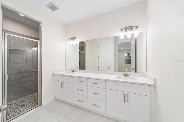 bathroom with vanity, a shower with shower door, and tile patterned flooring