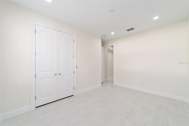 unfurnished bedroom featuring light tile patterned flooring and a closet