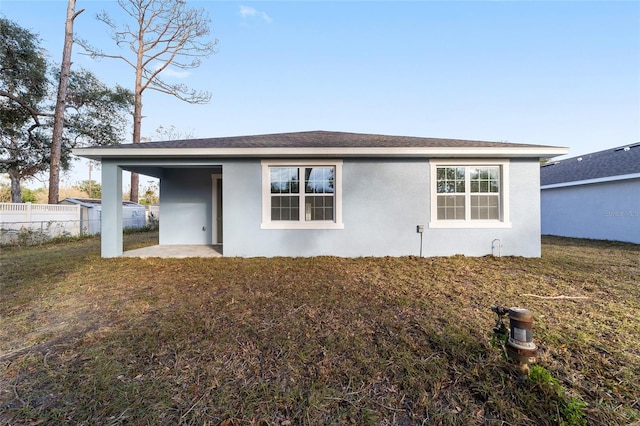 rear view of house with a patio and a yard