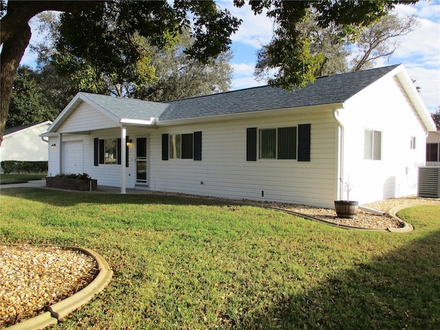 ranch-style home featuring cooling unit and a front yard