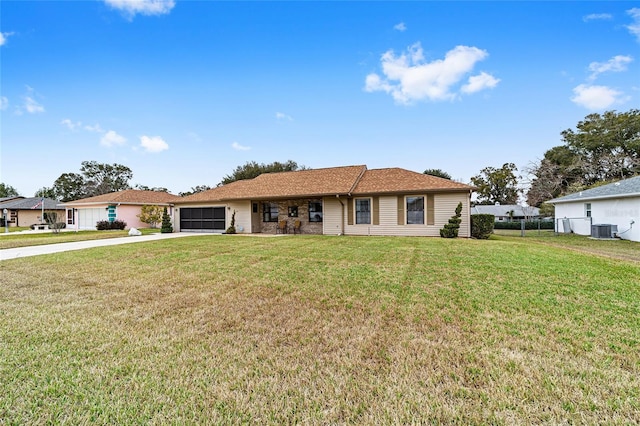 ranch-style home with central AC unit, a garage, and a front yard