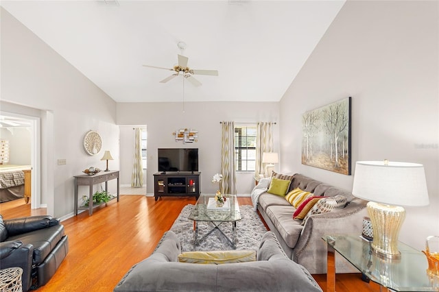 living room with wood-type flooring, high vaulted ceiling, and ceiling fan