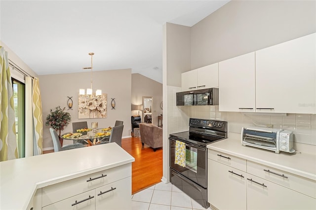 kitchen with black appliances, hanging light fixtures, light tile patterned floors, a notable chandelier, and white cabinets