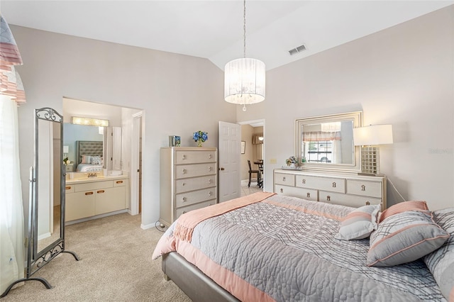 carpeted bedroom featuring ensuite bathroom, a chandelier, and vaulted ceiling