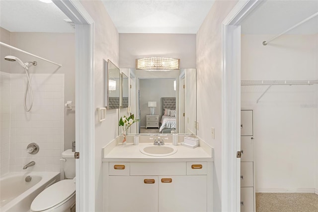 full bathroom featuring tiled shower / bath combo, vanity, and toilet