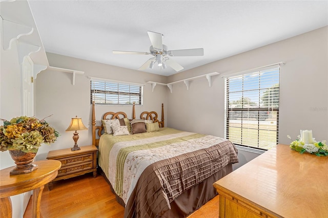 bedroom with multiple windows, light hardwood / wood-style floors, and ceiling fan