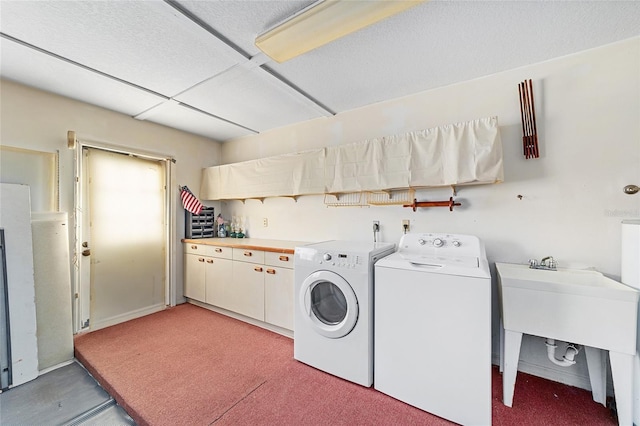 clothes washing area featuring cabinets, washing machine and dryer, sink, and carpet flooring