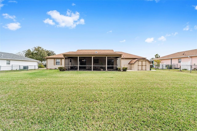 back of house with a yard, a storage unit, and a sunroom