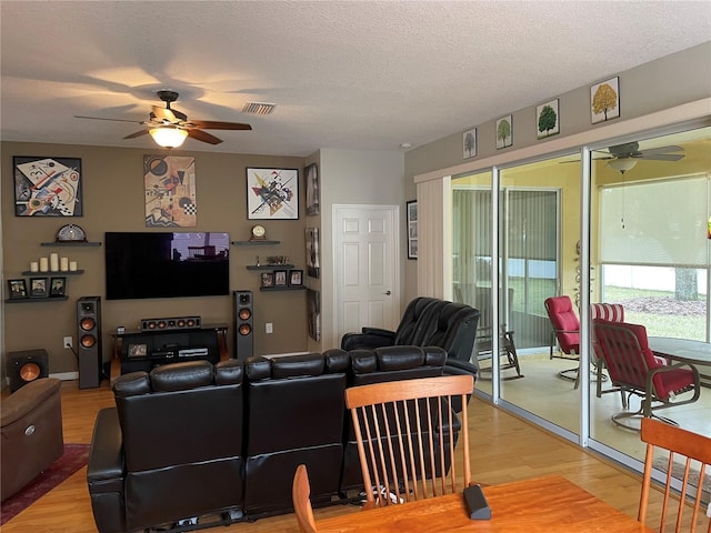 living room with ceiling fan, hardwood / wood-style floors, and a textured ceiling