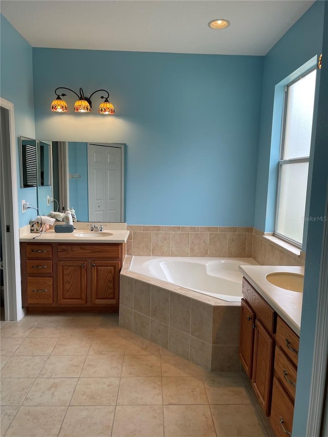 bathroom with vanity, tiled tub, and tile patterned floors