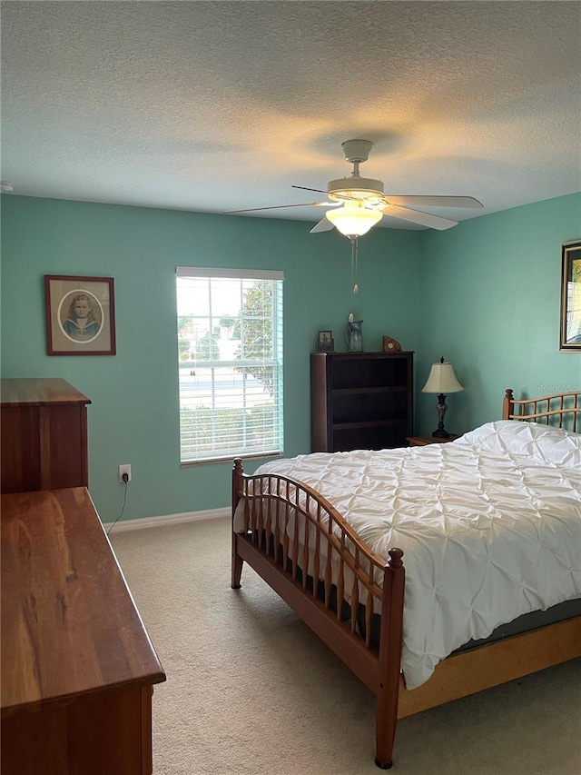 bedroom with light colored carpet, a textured ceiling, and ceiling fan