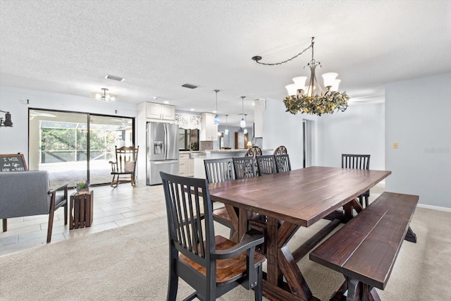 carpeted dining room with an inviting chandelier and a textured ceiling