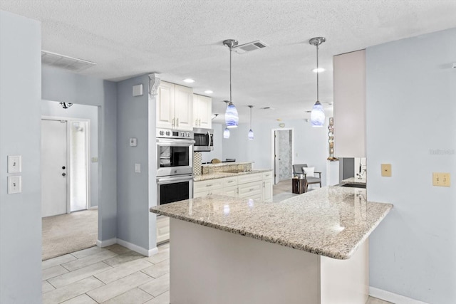 kitchen featuring decorative light fixtures, white cabinets, kitchen peninsula, stainless steel appliances, and light stone countertops