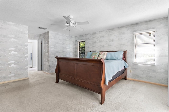 bedroom featuring multiple windows, a textured ceiling, and ceiling fan