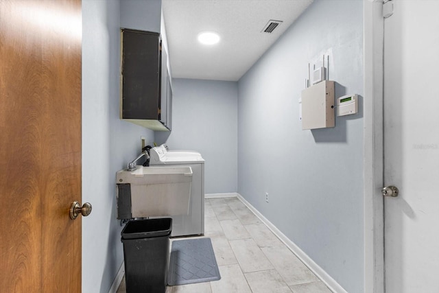 laundry room with cabinets, sink, a textured ceiling, and independent washer and dryer