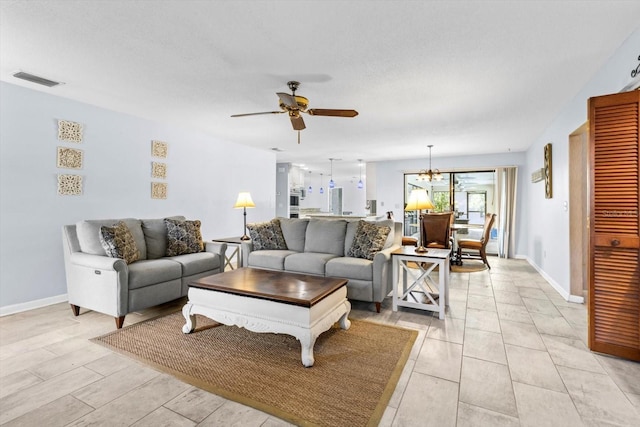 living room featuring ceiling fan with notable chandelier