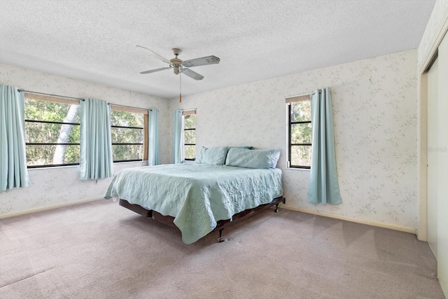 carpeted bedroom featuring a textured ceiling, a closet, and ceiling fan