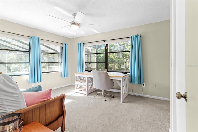 carpeted home office with ceiling fan and a textured ceiling