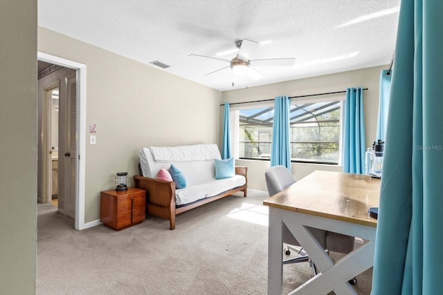 bedroom with light colored carpet, a textured ceiling, and ceiling fan