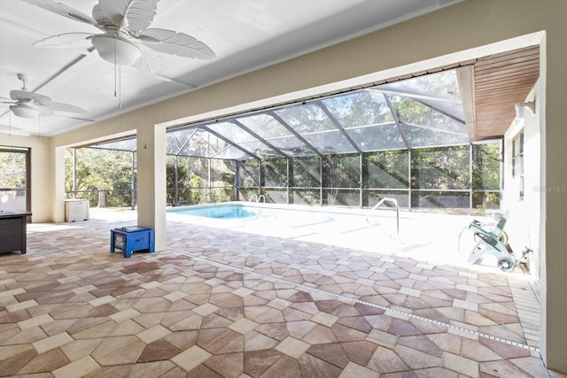 view of swimming pool with a patio, ceiling fan, and glass enclosure