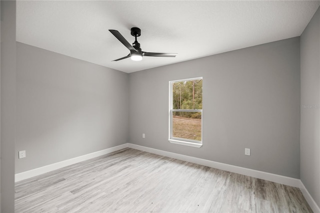 empty room with ceiling fan and light hardwood / wood-style floors