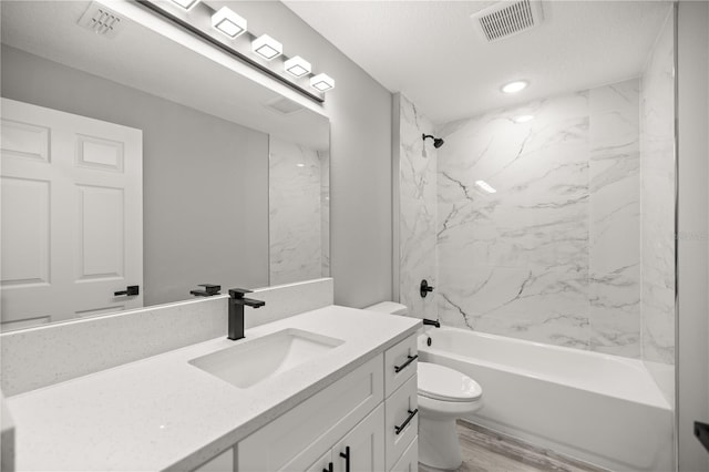 full bathroom with toilet, a textured ceiling, vanity, tiled shower / bath combo, and hardwood / wood-style floors