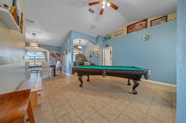 game room featuring light tile patterned flooring, ceiling fan, vaulted ceiling, and a textured ceiling