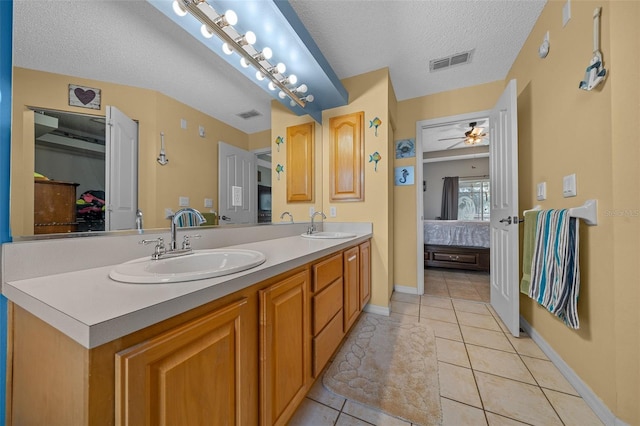 bathroom featuring tile patterned flooring, vanity, ceiling fan, and a textured ceiling