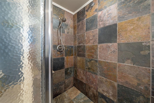 bathroom featuring ornamental molding and tiled shower