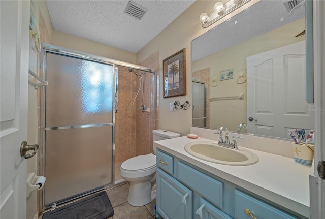 bathroom featuring vanity, an enclosed shower, a textured ceiling, and toilet