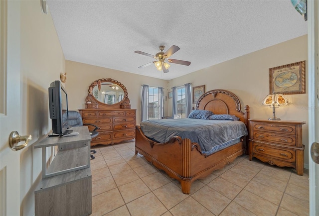 bedroom featuring light tile patterned flooring, ceiling fan, and a textured ceiling