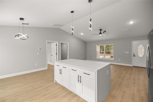 kitchen with white cabinetry, decorative light fixtures, light hardwood / wood-style floors, and lofted ceiling