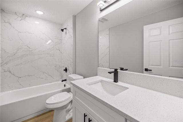 full bathroom featuring vanity, toilet, tiled shower / bath combo, and hardwood / wood-style floors