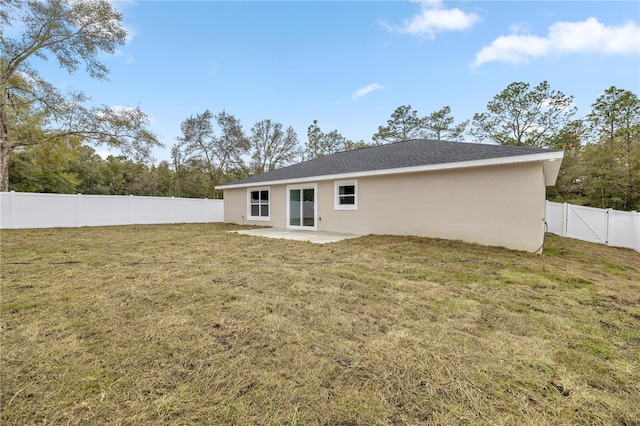 rear view of house featuring a lawn and a patio