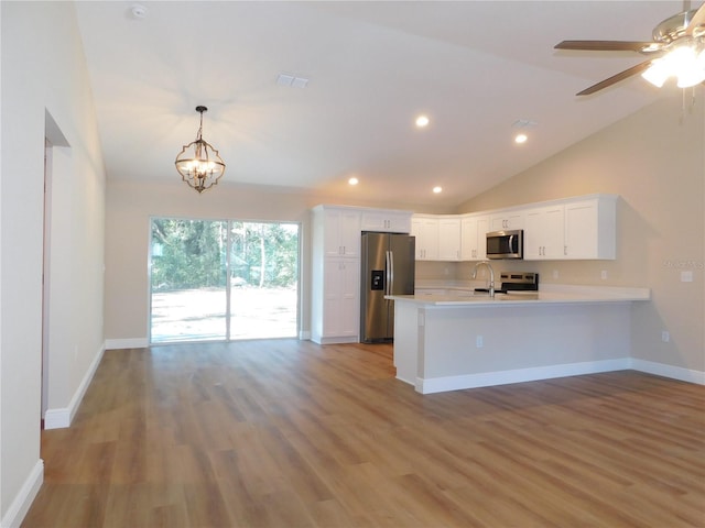 14268 SE 27th Ct, Summerfield, FL 34491 - kitchen featuring appliances with stainless steel finishes, a peninsula, white cabinets, light countertops, and wood finished floors