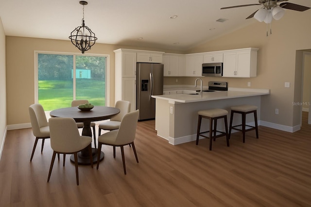 14268 SE 27th Ct, Summerfield, FL 34491 - kitchen with stainless steel appliances, wood finished floors, white cabinets, a peninsula, and light countertops