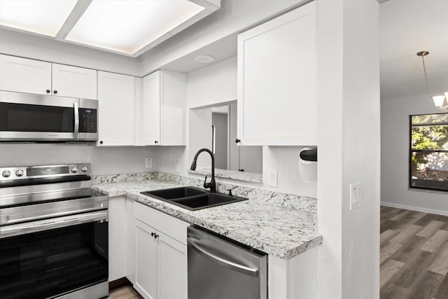 kitchen with sink, dark wood-type flooring, stainless steel appliances, and white cabinets