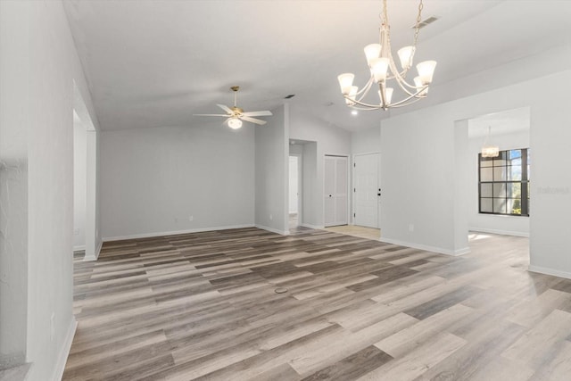 unfurnished living room with hardwood / wood-style flooring, lofted ceiling, and ceiling fan with notable chandelier