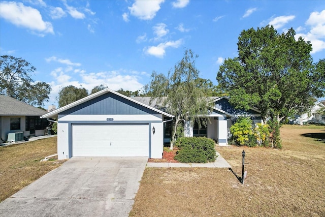 ranch-style home with cooling unit, a garage, and a front lawn