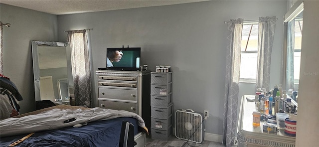 bedroom featuring hardwood / wood-style flooring and a textured ceiling