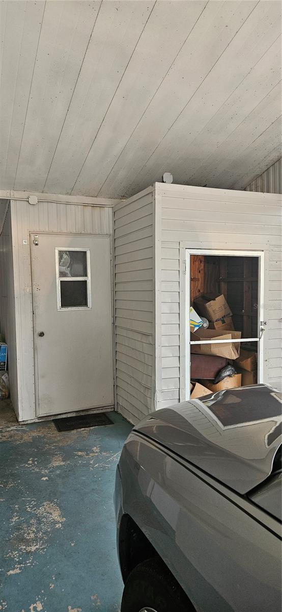 garage featuring wooden ceiling and wood walls